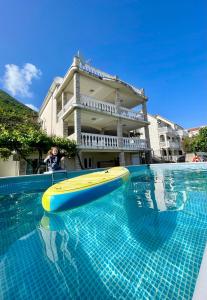 una lavagna gialla e blu in piscina di Family House with pool & sea view a Bijela