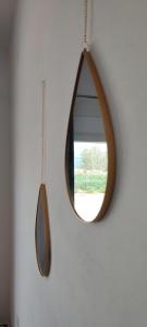 un espejo redondo colgado en una pared blanca en White Lotus seaside apartment en Kini