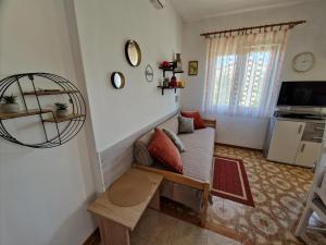 a living room with a couch and a tv at Apartments Godena in Rovinj