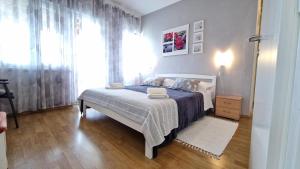ein Schlafzimmer mit einem Bett und einem großen Fenster in der Unterkunft Apartments Godena in Rovinj