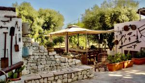 a patio with an umbrella and a stone wall at Antica Masseria in Padresergio