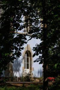 科爾維納克的住宿－Domaine de Locguénolé & Spa - Relais & Chateaux，树中间有窗户的建筑