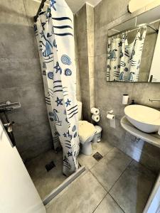 ein Badezimmer mit einem WC, einem Waschbecken und einem Spiegel in der Unterkunft Anna in Megali Ammos