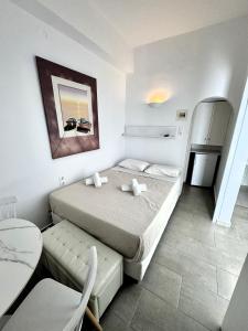 Schlafzimmer mit einem Bett, einem Tisch und einem Kühlschrank in der Unterkunft Anna in Megali Ammos