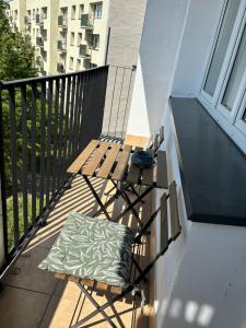 un banc en bois assis sur un balcon avec un oreiller dans l'établissement Nocleg na doby S 61 ROAD, à Suwałki