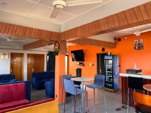 Habitación con paredes de color naranja, mesa y sillas. en AG HOTEL Ouaga en Uagadugú