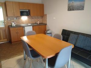 uma cozinha e sala de estar com uma mesa de madeira e cadeiras em Apartmány Pod Sjezdovkou em Cervena Voda
