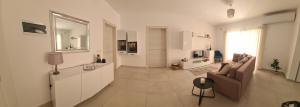 un soggiorno bianco con divano e TV di Modern-Studio apartment in Qawra Malta a San Pawl il-Baħar