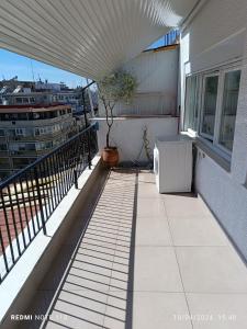 a balcony of a building with a tree on it at Zara's Boutique near Venizelos metro station in Thessaloniki