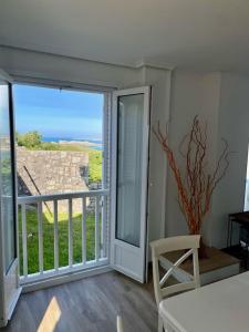 a room with a balcony with a view of the ocean at La casuca de San Juan de la canal in Santa Cruz de Bezana +33 photos