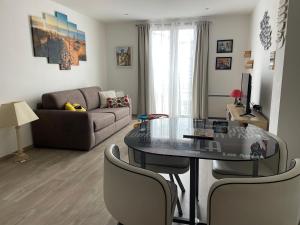 a living room with a table and a couch at Appartement cocooning plage des lecques in Saint-Cyr-sur-Mer