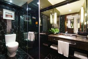 y baño con aseo, lavabo y espejo. en Jinrui Jiatai Hotel Xiamen - Convention and Exhibition Center-Gudishi Subway Station, en Xiamen