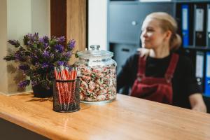 a woman sitting at a table with a jar of candy at 16eur - Fat Margaret's in Tallinn +31 photos