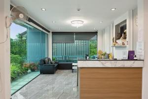 a kitchen and a living room with a couch at De Piraya residence in Ban Bo Sai Klang