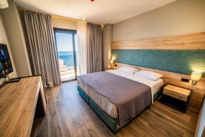 a hotel room with a bed and a large window at Hotel Saranda International in Sarandë