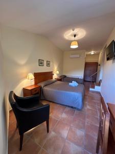 a bedroom with a bed and a chair at Hostal Centre Del Montsec in Llimiana