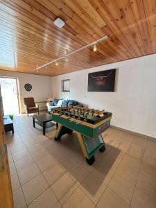 una sala de estar con mesa de ping pong. en La Villa des Vennes, en Heure