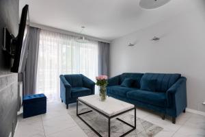 sala de estar con sofá azul y mesa en Apartament 208, en Międzyzdroje