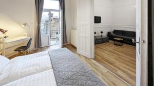 a bedroom with a bed and a living room with a couch at 3 room apartment in the beautiful street in Budapest