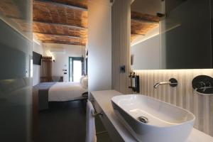 a bathroom with a sink and a bed in a room at Hotel El Rosal de Cudillero in Cudillero