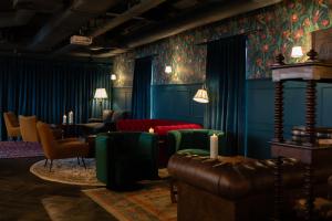 a living room with blue walls and green furniture at Moxy Edinburgh Fountainbridge in Edinburgh