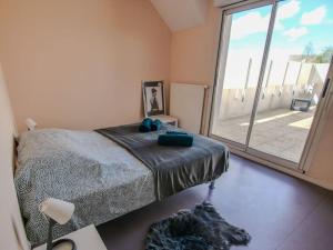 a bedroom with a bed and a large window at Appartement terrasse in Saint-Jean-de-Daye