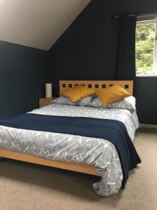 um quarto com uma cama grande e paredes azuis em Oxfordshire Village Apartment em Rotherfield Peppard