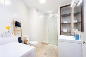 a white bathroom with a toilet and a sink at OkStay Apt Bencomo 50 m from the beach in Puerto de la Cruz +18 photos