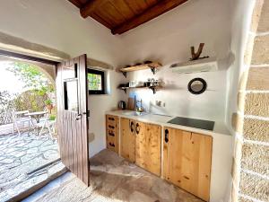 a kitchen with a sink and a door to a patio at Villa ABBA in Plaka +86 photos