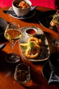 a table with a plate of food and a glass of wine at Moxy Edinburgh Fountainbridge in Edinburgh