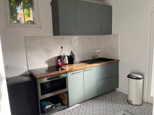 kuchnia z szarymi szafkami i blatem w obiekcie Cosy appartement in Paris w Paryżu