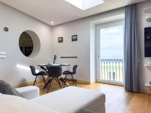 ナポリにあるVilla Elba • Panoramicaのテーブルと椅子と窓のあるリビングルーム