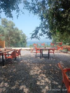 a group of tables and chairs with the ocean in the background at Eses Camping in Muğla