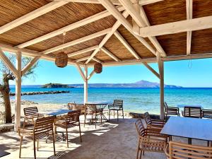 a restaurant on the beach with tables and chairs at Villa ABBA in Plaka