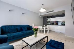 - un salon avec un canapé bleu et une table dans l'établissement Apartament 208, à Międzyzdroje