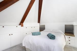 a bedroom with white cabinets and a bed with two blue towels at OkStay Penthouse Bencomo with beach views in Puerto de la Cruz