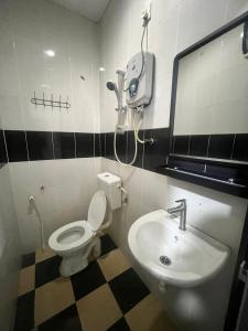 ein Bad mit einem WC und einem Waschbecken in der Unterkunft Captain Hotel in Sitiawan