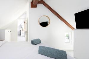 a white bedroom with a mirror and a bed at OkStay Penthouse Bencomo with beach views in Puerto de la Cruz