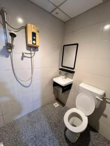 ein Bad mit einem WC und einem Waschbecken in der Unterkunft Captain Hotel in Sitiawan