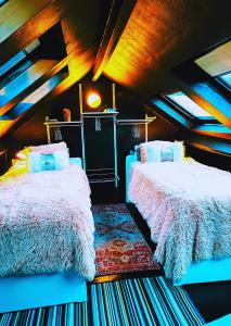een slaapkamer met 2 bedden op een zolder bij Duplex Atypique à Bruxelles in Brussel