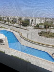 a view of a swimming pool through a fence at Premium Sea View Chalet in Azha Ain Sokhna in Ain Sokhna