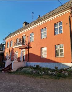 a large orange building with a staircase in front of it at Remuganes suite - Porvoon Linna in Porvoo