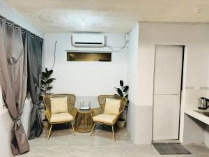 a living room with two chairs and a table at The SD Apartment in Camiling