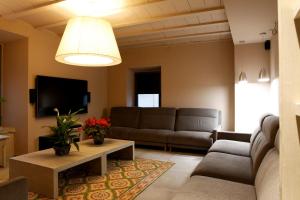 sala de estar con sofá y TV en Cal Miqueló Puiggros, en Puiggròs