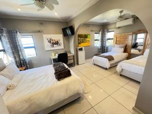 a large bedroom with two beds and a mirror at La Vue in Port Shepstone