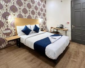 新德里的住宿－Nidra Hotel，一间卧室配有一张带蓝色枕头的大床
