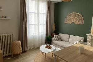 a living room with a couch and a table at Le cocon du Faubourg in Vendôme +3 photos