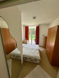 a bedroom with a bed and a window and a mirror at Lelle Beach Club in Balatonlelle
