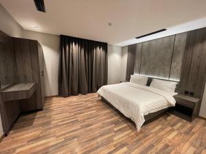 a bedroom with a bed and a wooden floor at شقق درر رامه للشقق المخدومة 2 in Riyadh