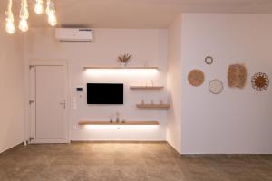 a living room with a television on a wall at armonia tinos in Tinos